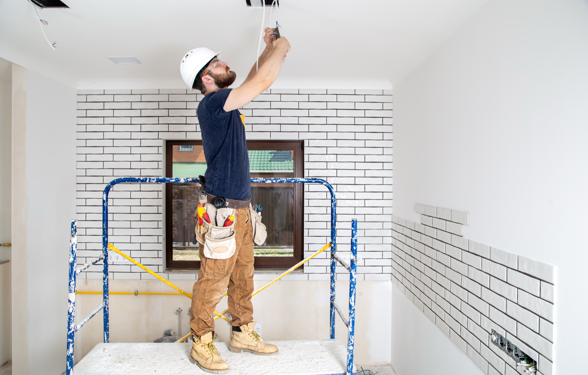 Electrician installing ceiling wiring during a Melbourne home renovation