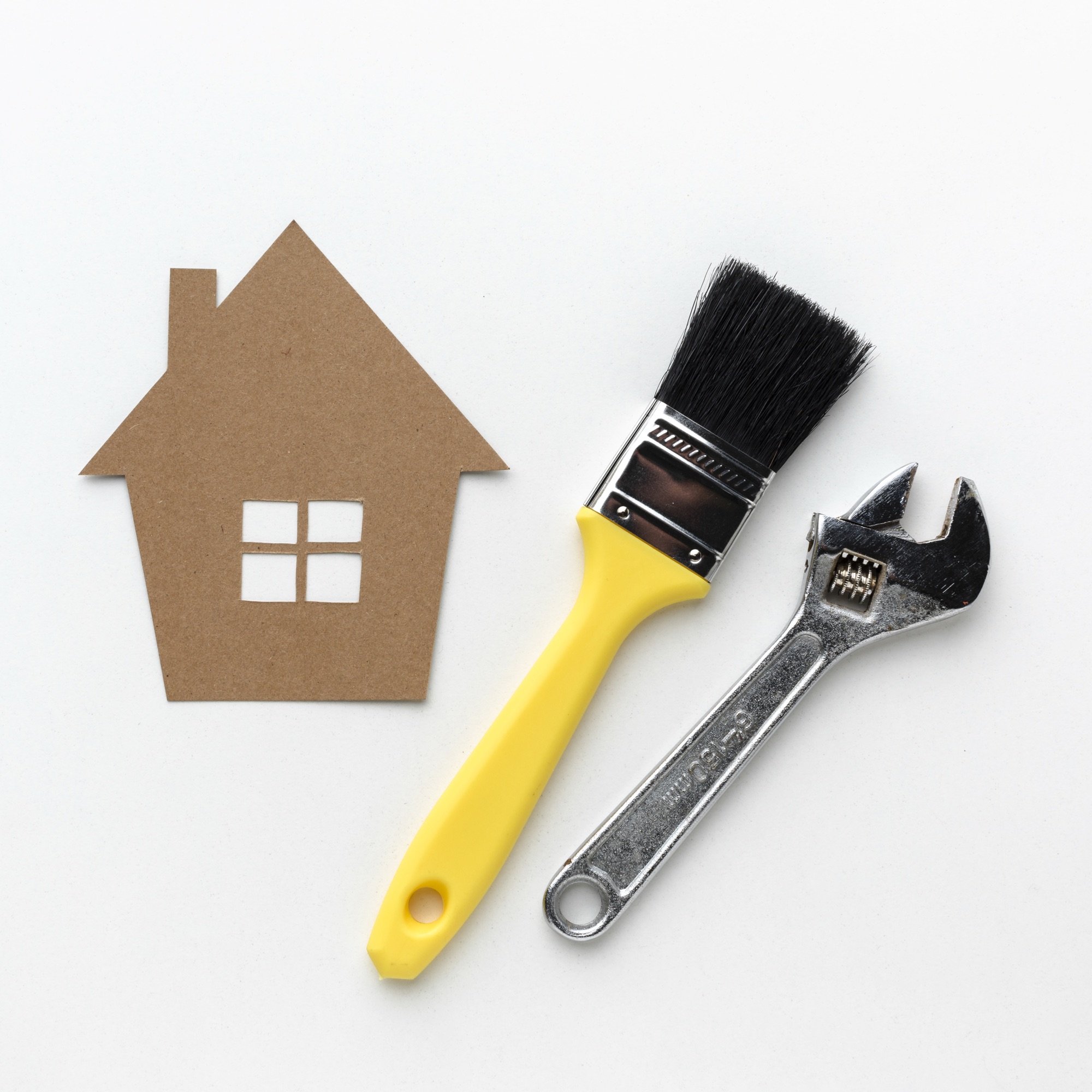 Paper house with paintbrush and spanner for home renovation specialists