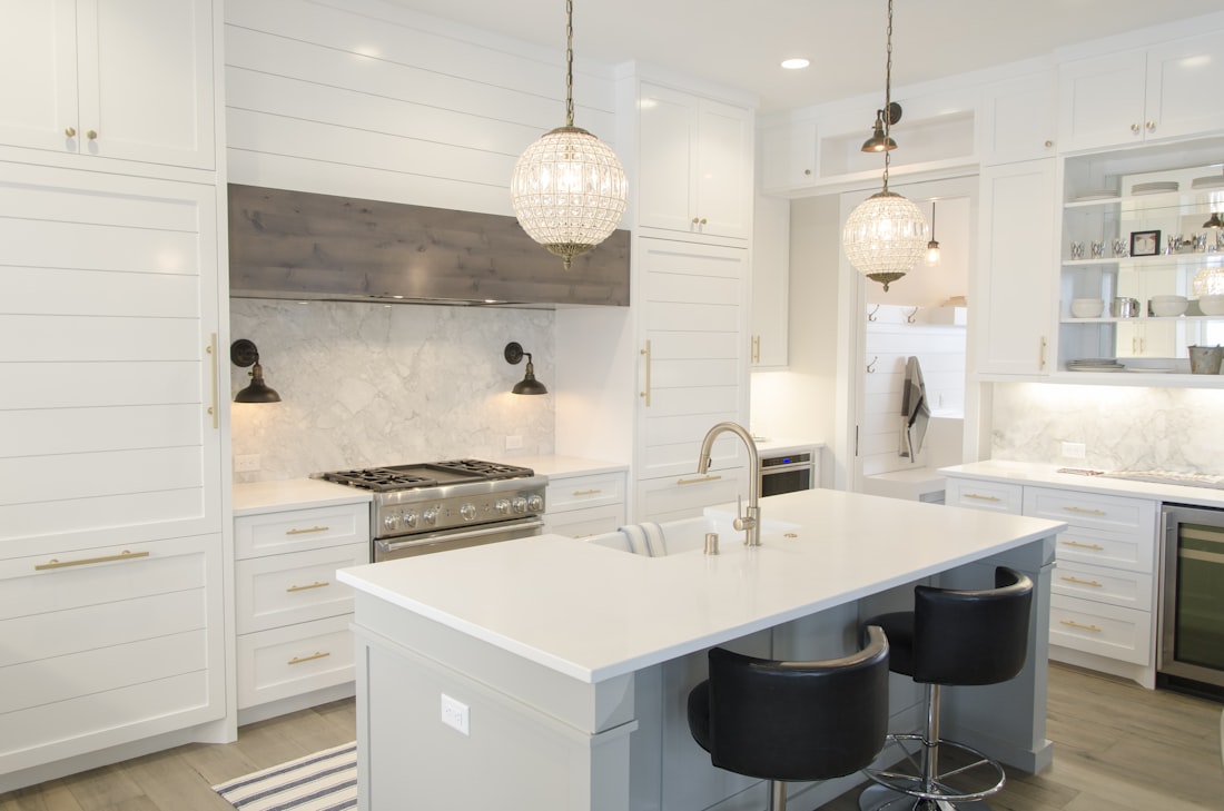 Finished white kitchen renovation with island bench, stone splashback and pendant lights